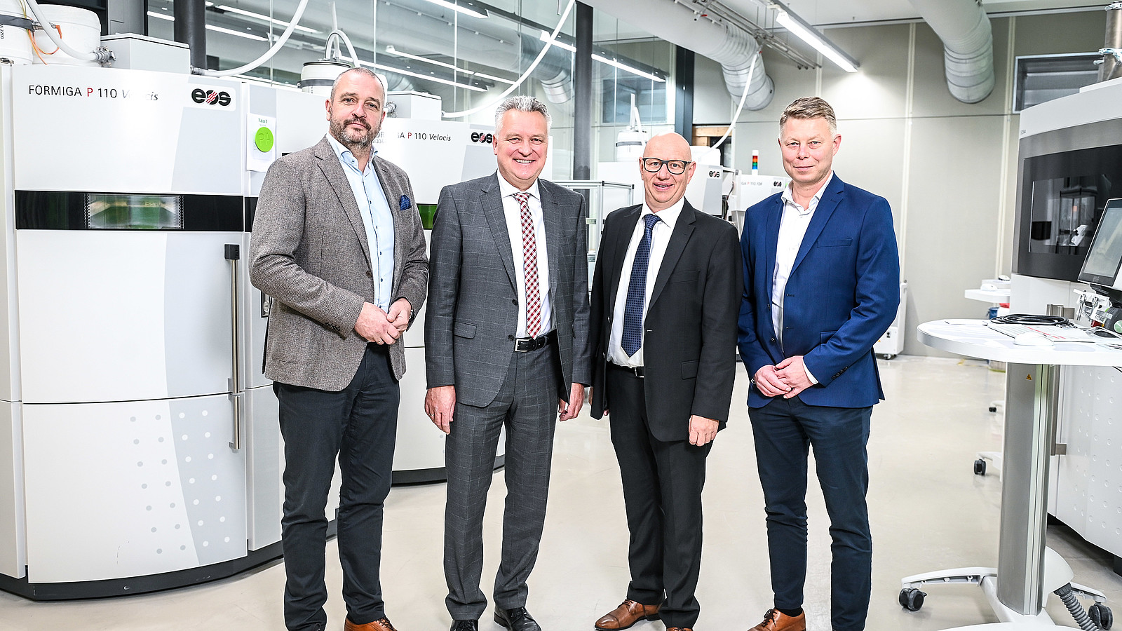 Das Bild zeigt den CFO und den Sales Director der Prototalgruppe gemeinsam mit den 1zu1 Geschäftsführern Wolfgang Humml und Hannes Hämmerle im 3D Druck Maschinenpart mit der EOS P500 im Rahmen der Ankündigung der 1zu1 Übernahme im November 2021.