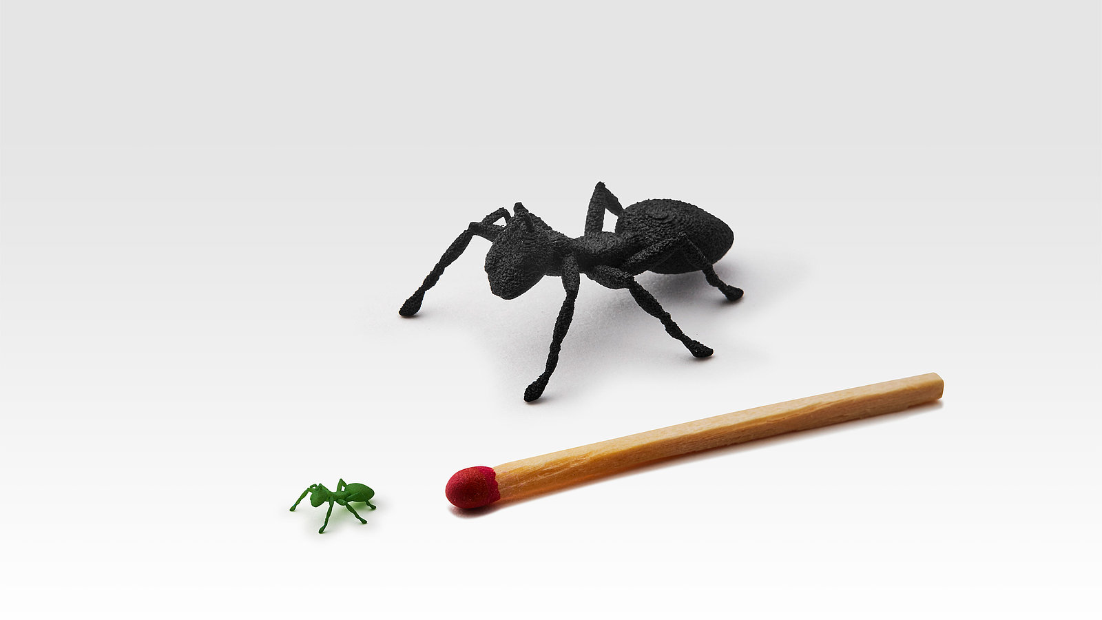 Das Bild zeigt eine große lasergesinterte Ameise in schwarz, sowie eine kleine grüne lasergesinterte Ameise in der Größe eines Kopfes eines Streichholzes, welche die Möglichkeiten der neuen FDR Technologie verdeutlichen soll.