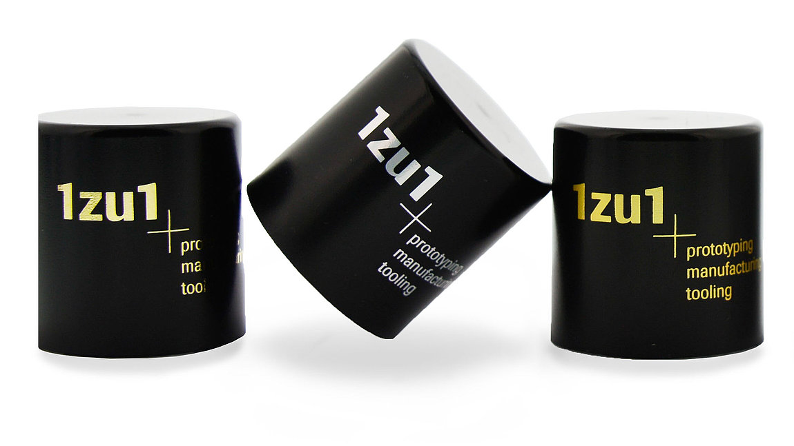Schwarze und weiße Plastikkappen mit 1zu1 Logo drauf
